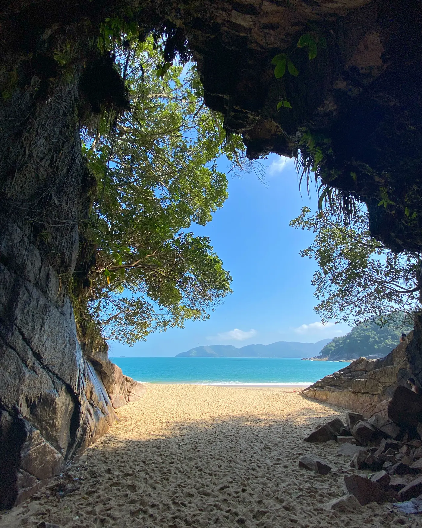 Arco de pedra da Gruta que Chora emoldurando o mar da Praia da Sununga, em Ubatuba — foto autoral de Renan Life