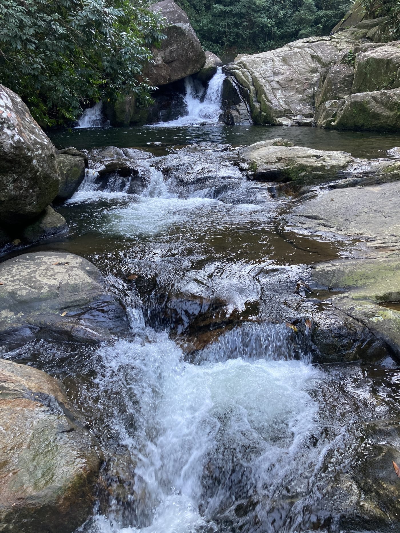 Água descendo em degraus entre pedras na Cachoeira dos Três Poços, no Camburi