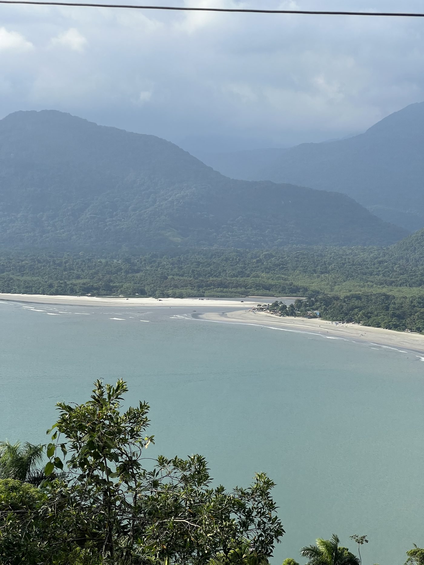 Praia longa da Almada vista do alto com a serra coberta de mata