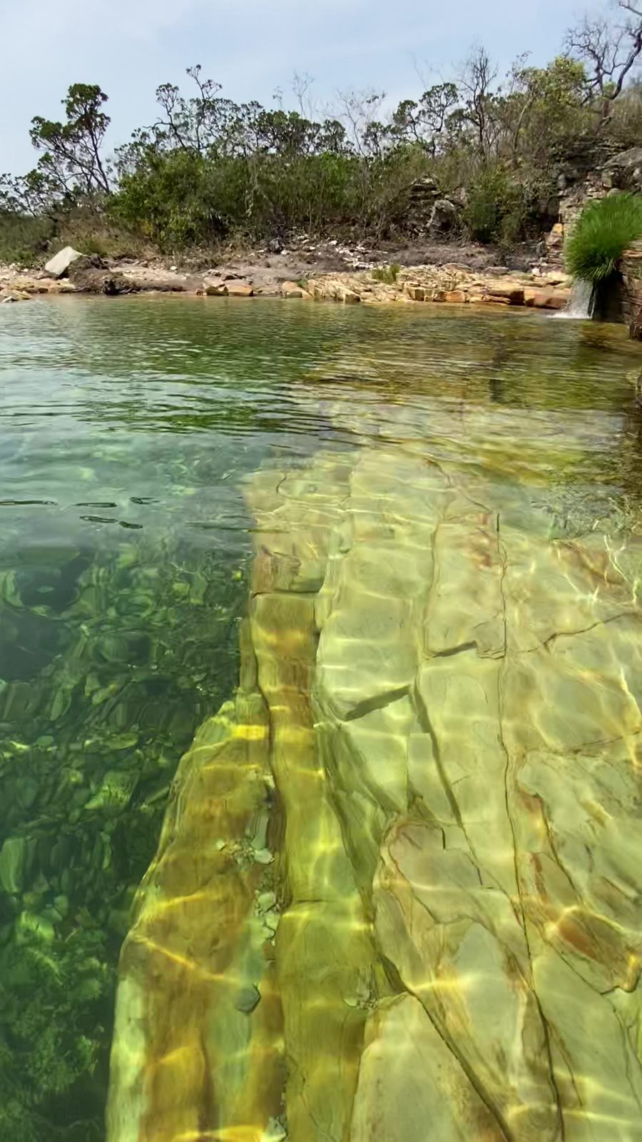 Água transparente mostrando a laje de pedra no fundo do rio