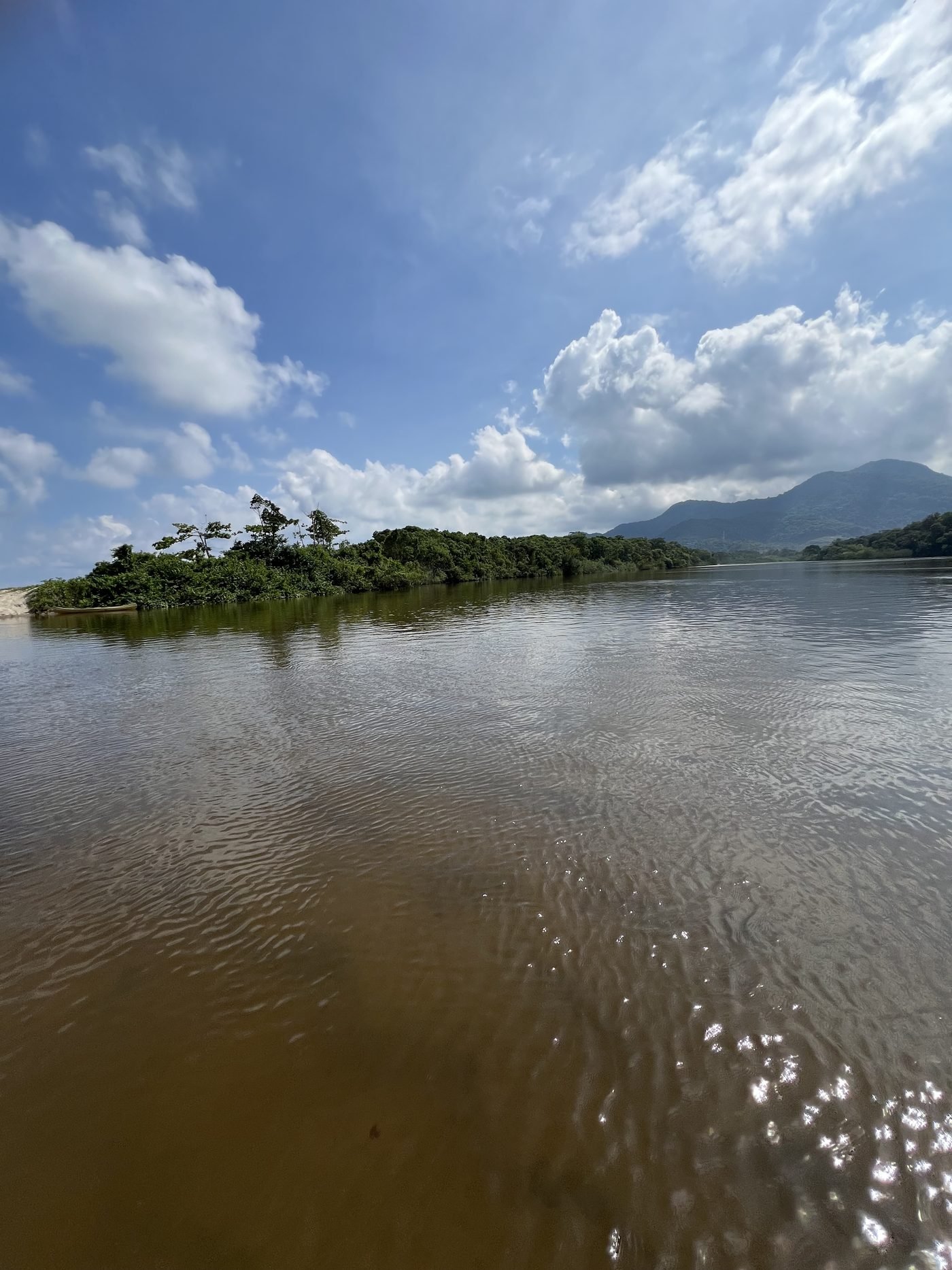 Rio largo e calmo no Puruba com ilhota de mata e serra ao fundo