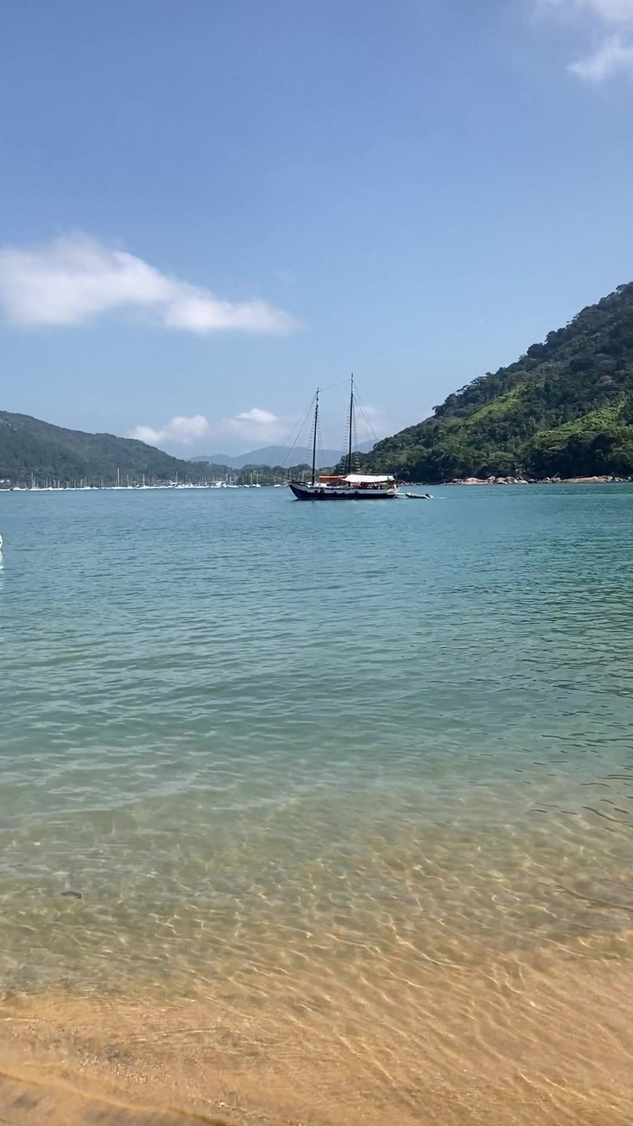 Barco ancorado em baía de água verde em Ubatuba