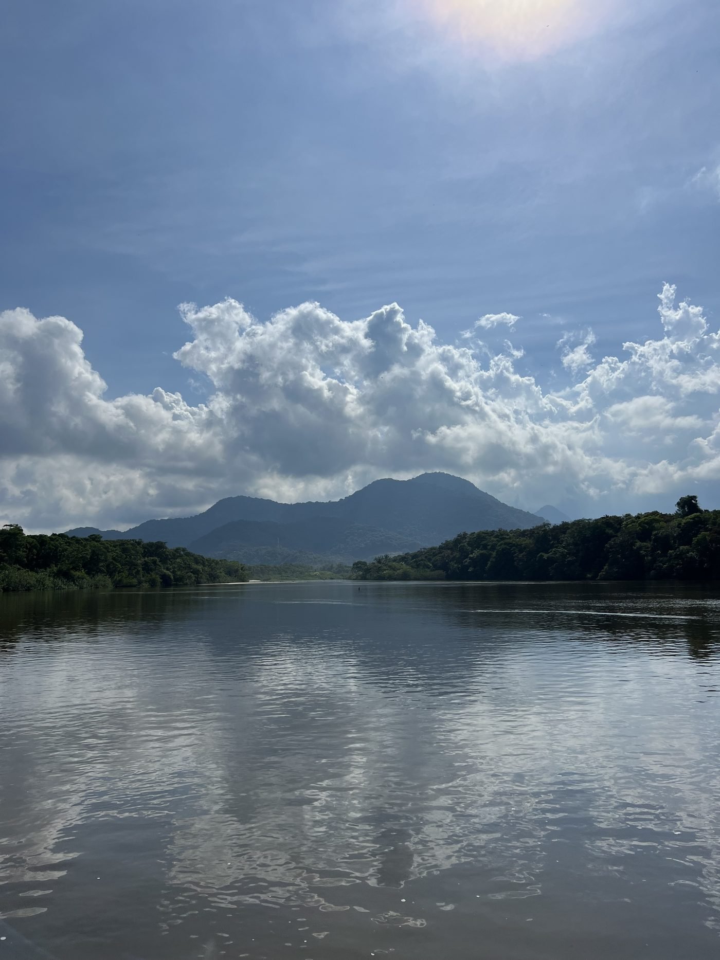 Rio Puruba parado refletindo as nuvens e a serra