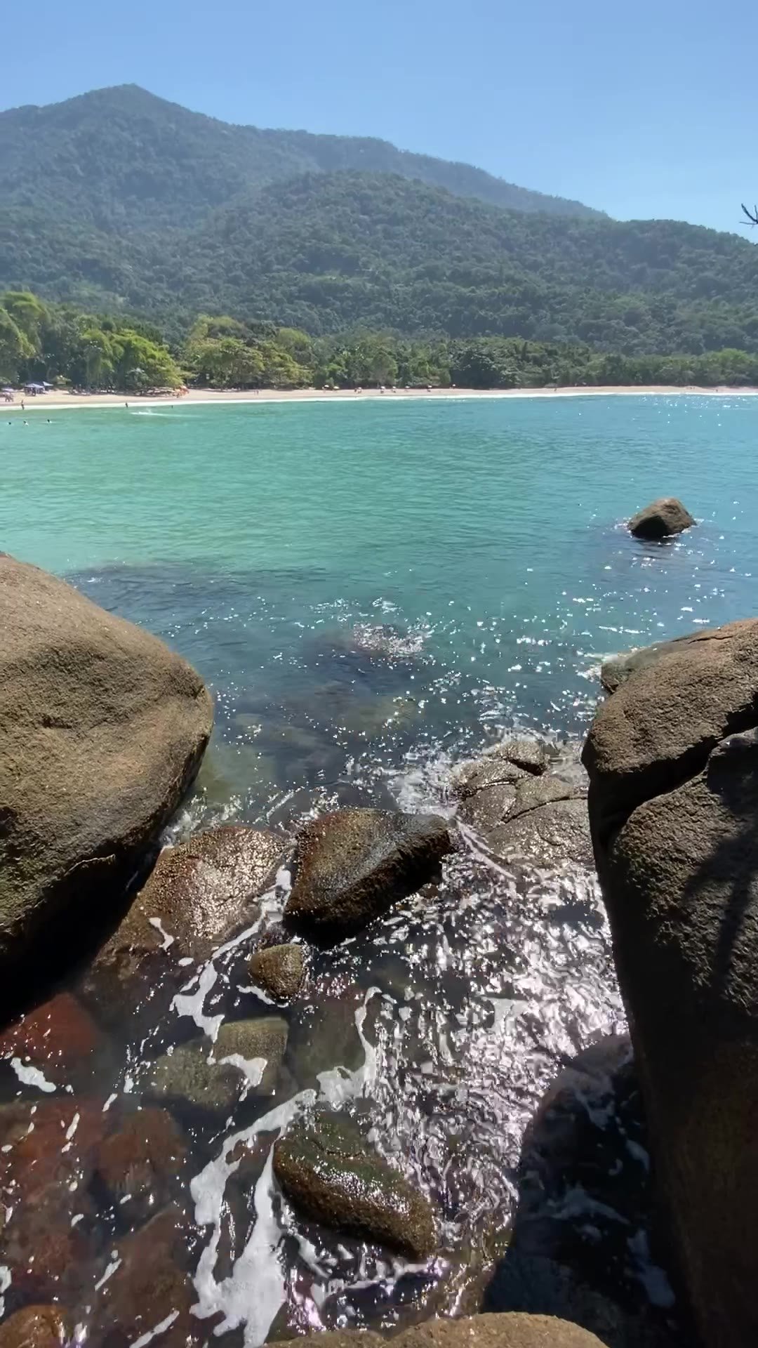 Pedras arredondadas e água verde-turquesa na Praia do Português