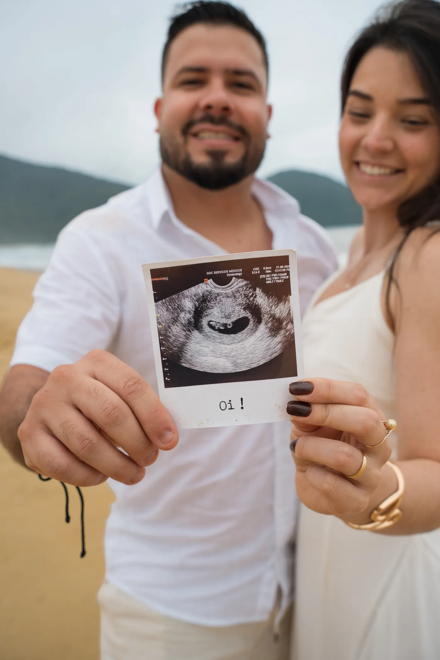 Casal segurando o ultrassom em primeiro plano — foto autoral de Renan Life, Ubatuba