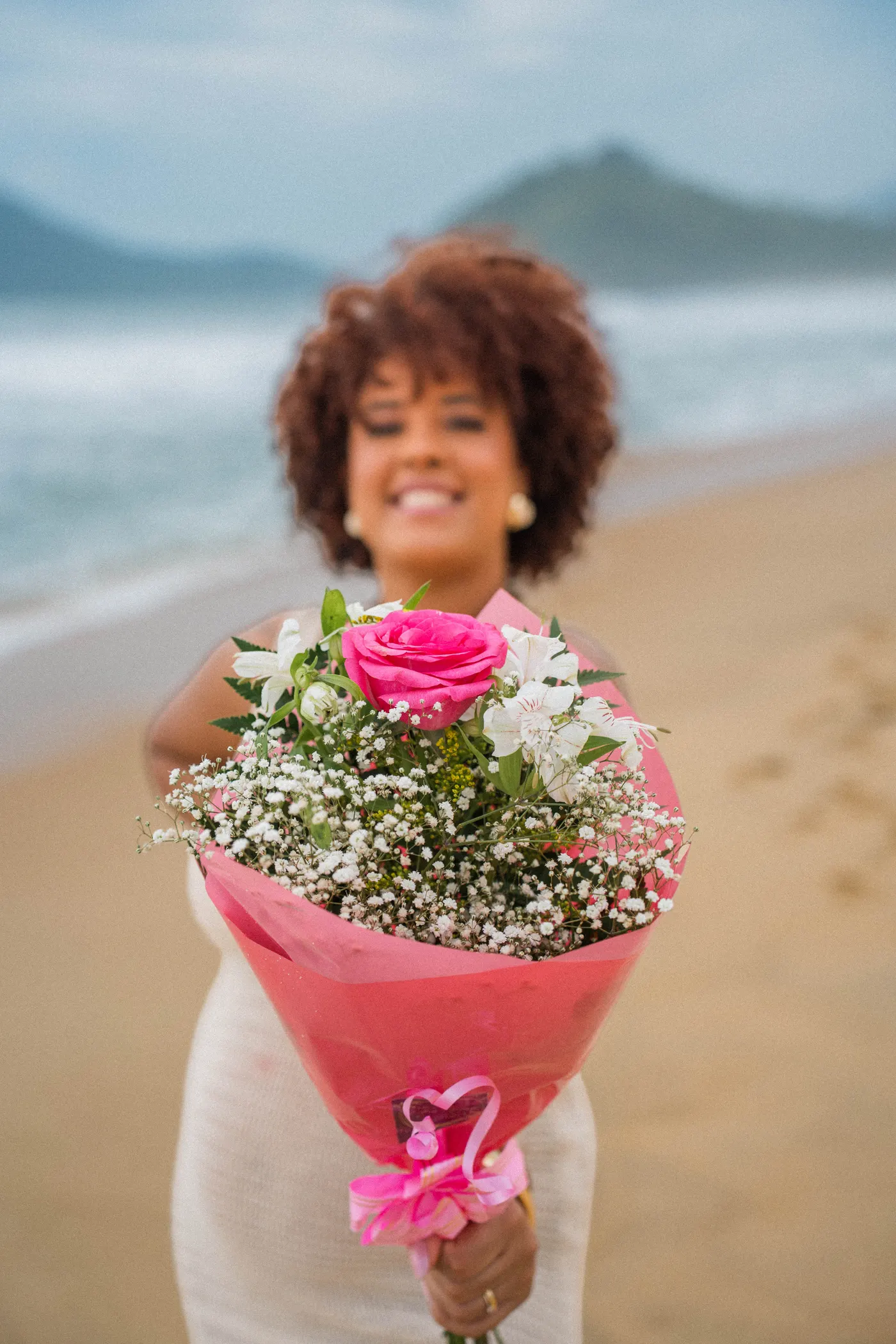 Mãe sorrindo com o buquê rosa depois da revelação — foto autoral de Renan Life, Ubatuba