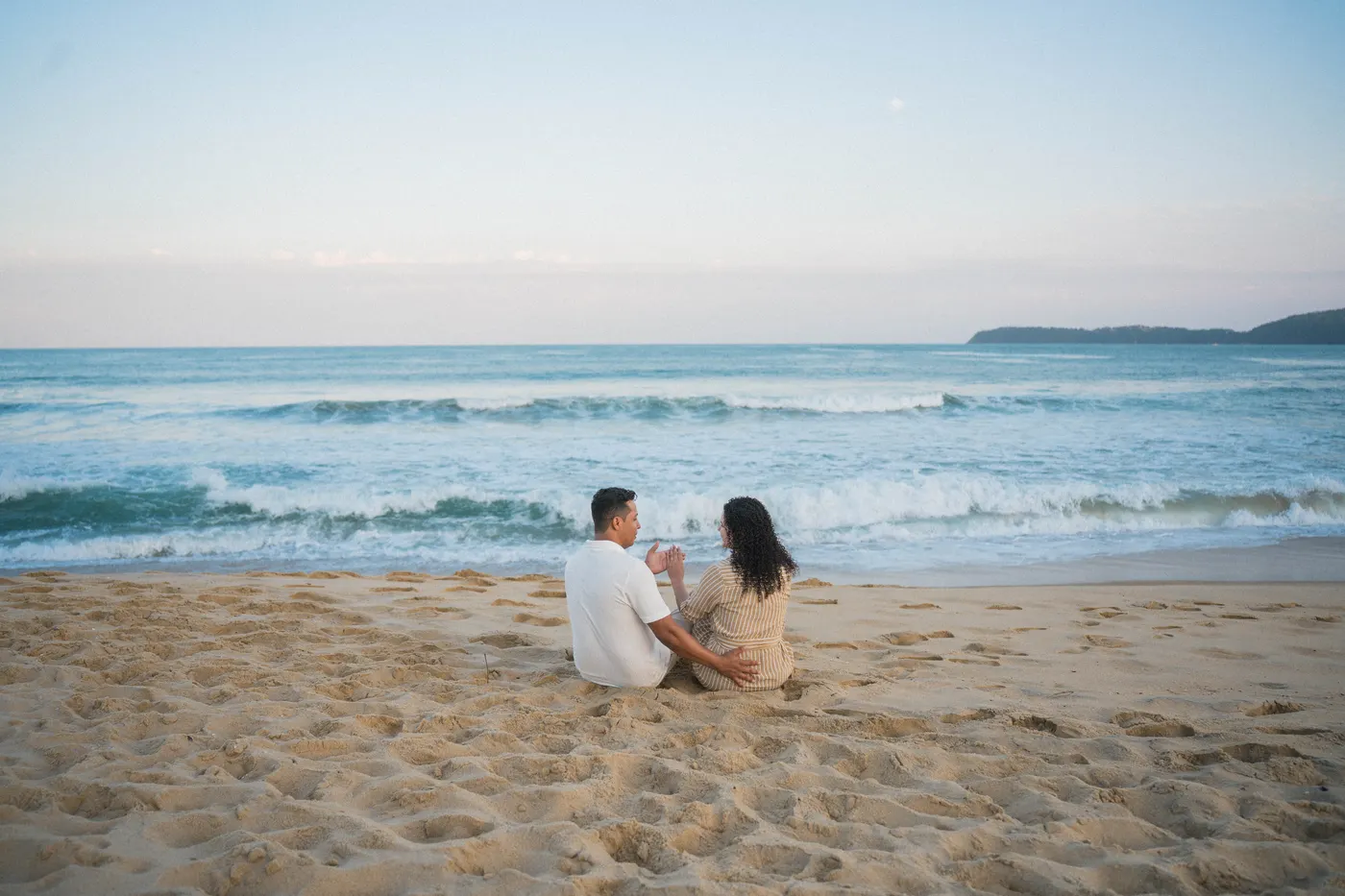 Casal sentado na areia olhando o mar no fim da tarde — foto autoral de Renan Life, Ubatuba