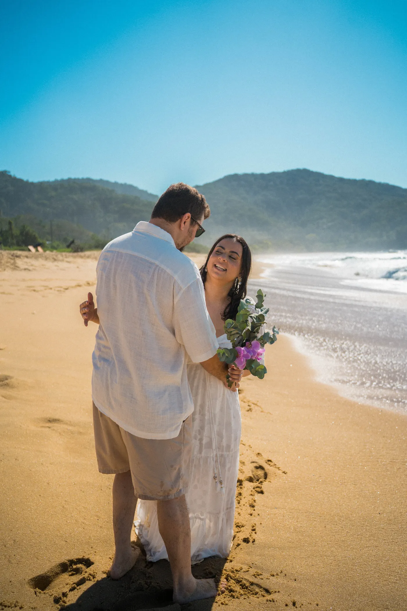 O casal abraçado na beira do mar durante o ensaio de família — foto autoral de Renan Life, Ubatuba