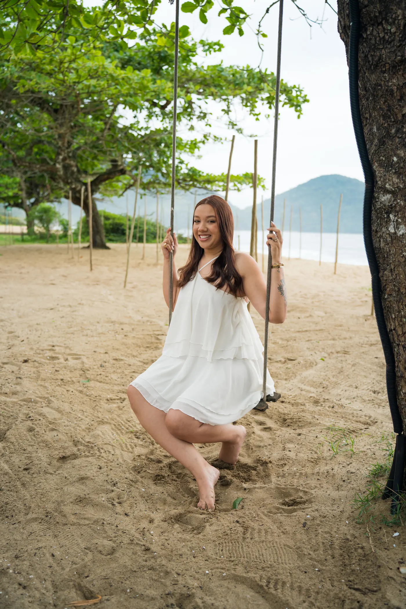 Mulher sorrindo no balanço de corda embaixo da árvore — foto autoral de Renan Life, Ubatuba