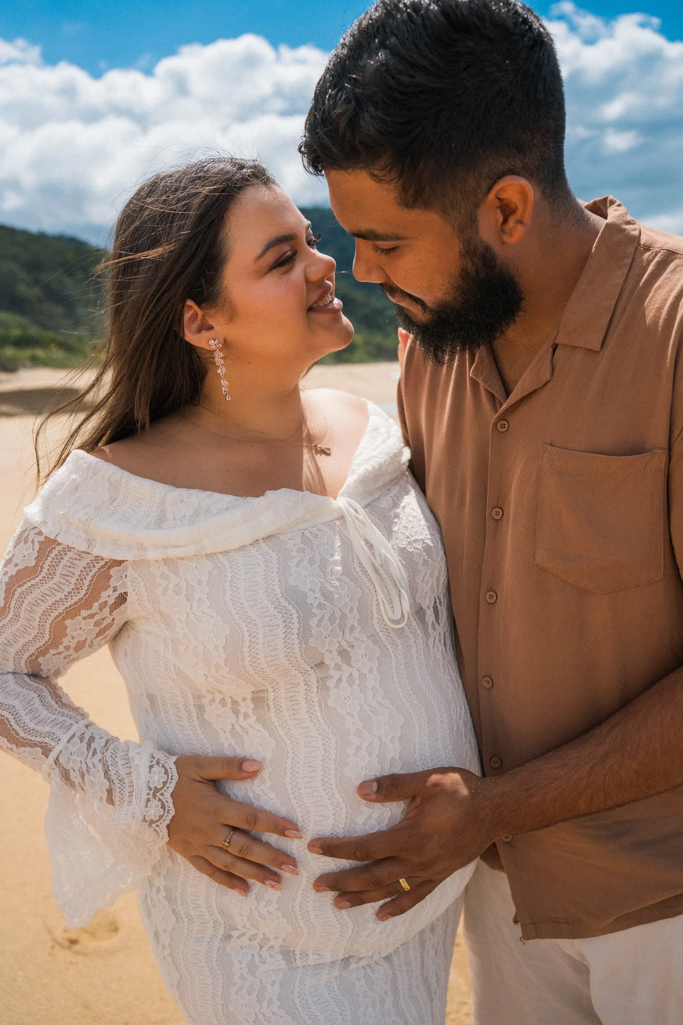 Casal com as mãos na barriga olhando um pro outro — foto autoral de Renan Life, Ubatuba