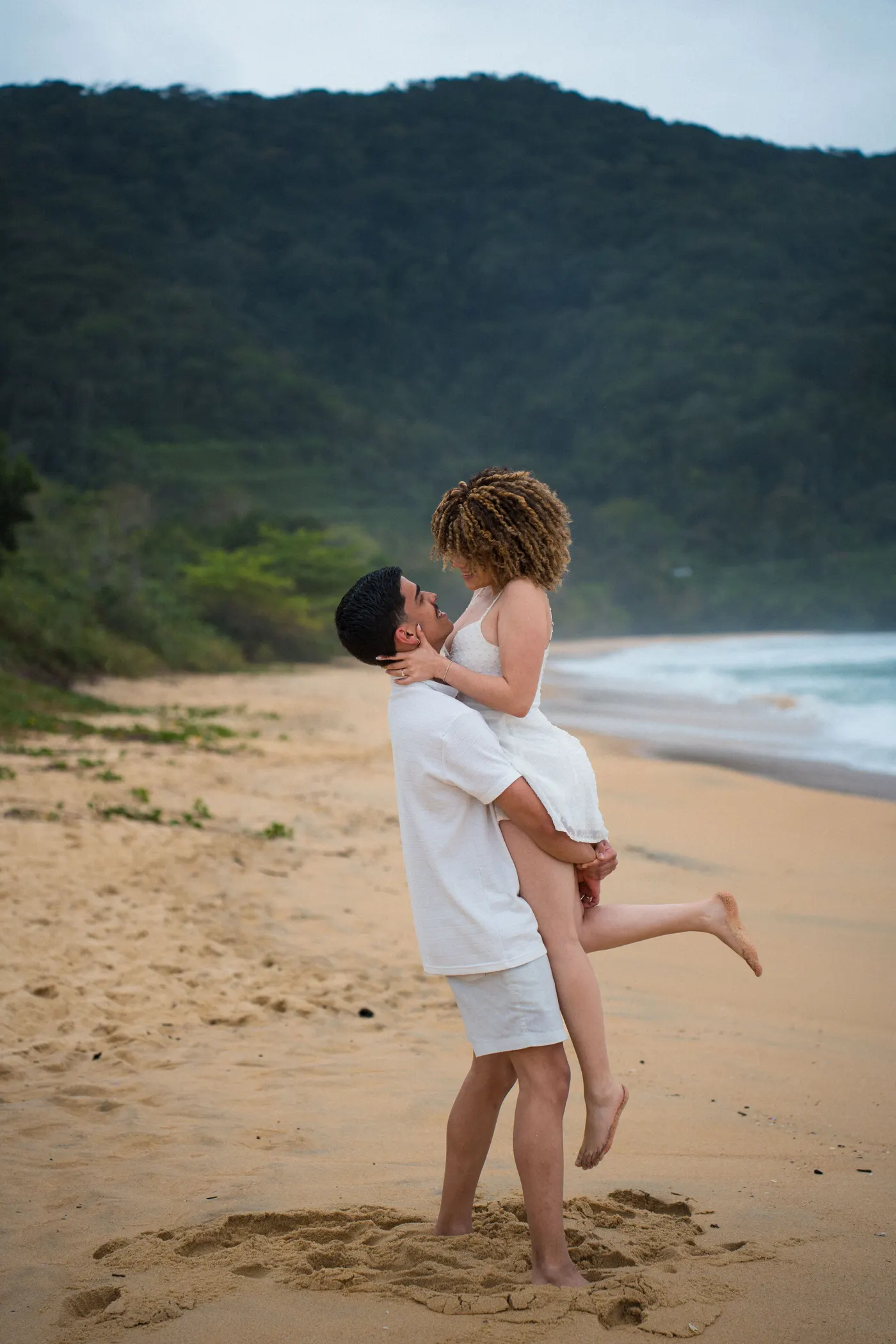A comemoração: ele levanta a noiva num abraço na areia — foto autoral de Renan Life, Ubatuba