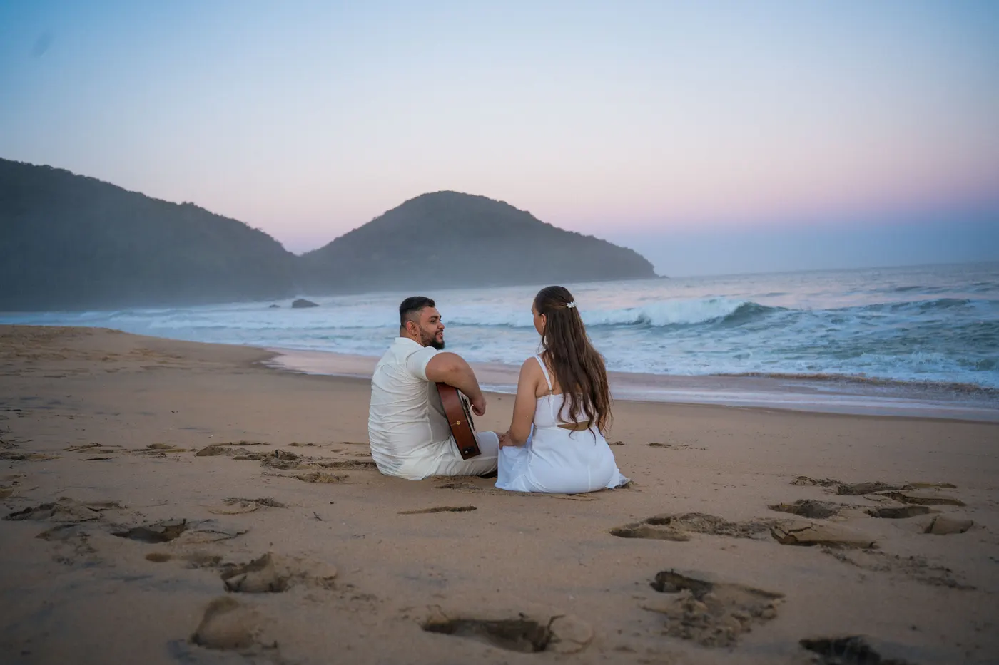Noivos sentados de longe na areia na hora azul — foto autoral de Renan Life, Ubatuba