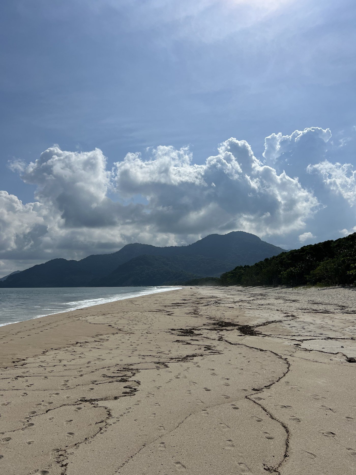 Praia do Puruba, Ubatuba, faixa de areia vazia com a serra ao fundo