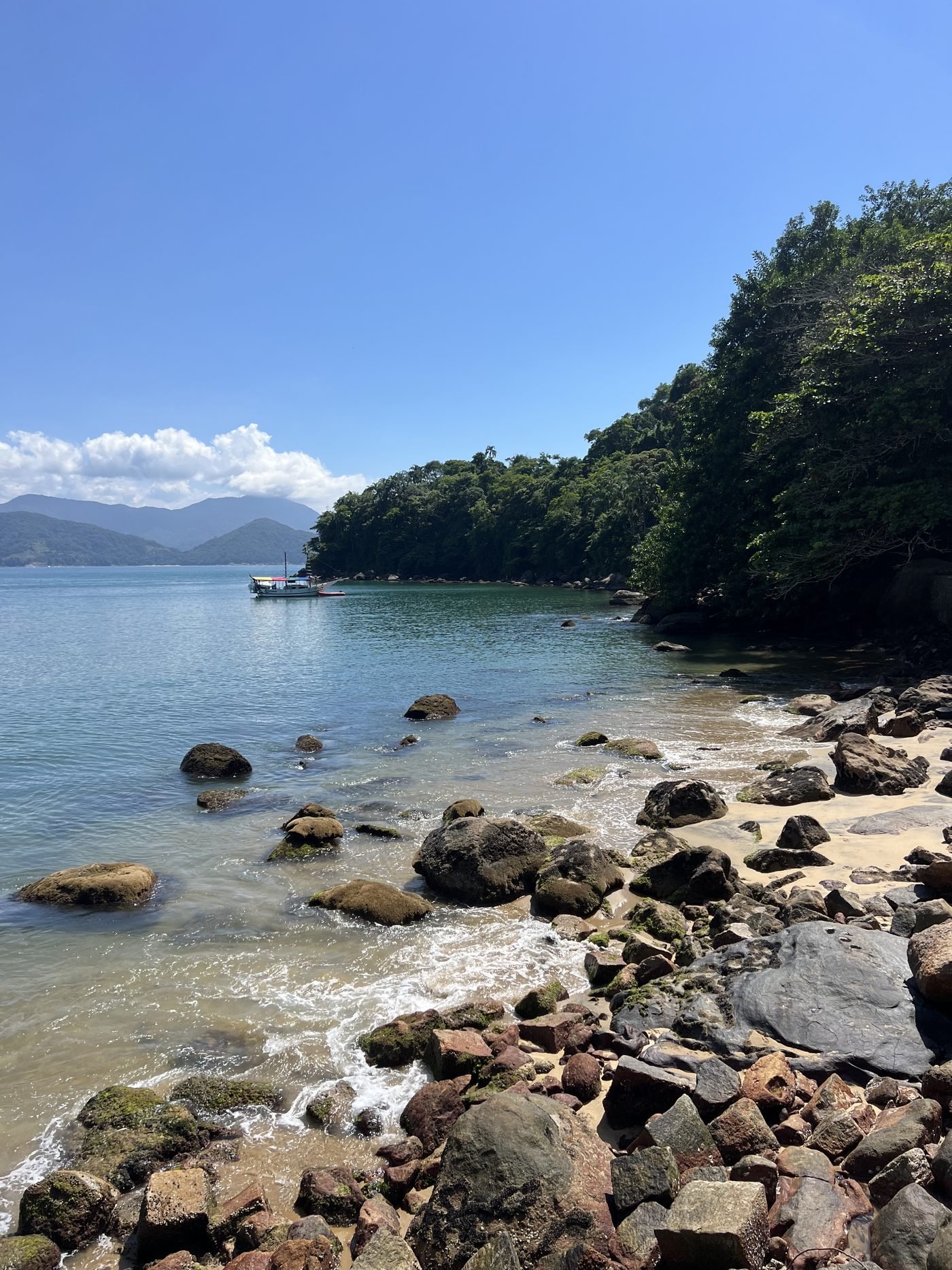 Pedras e mar calmo na Prainha do Cais, em Ubatuba