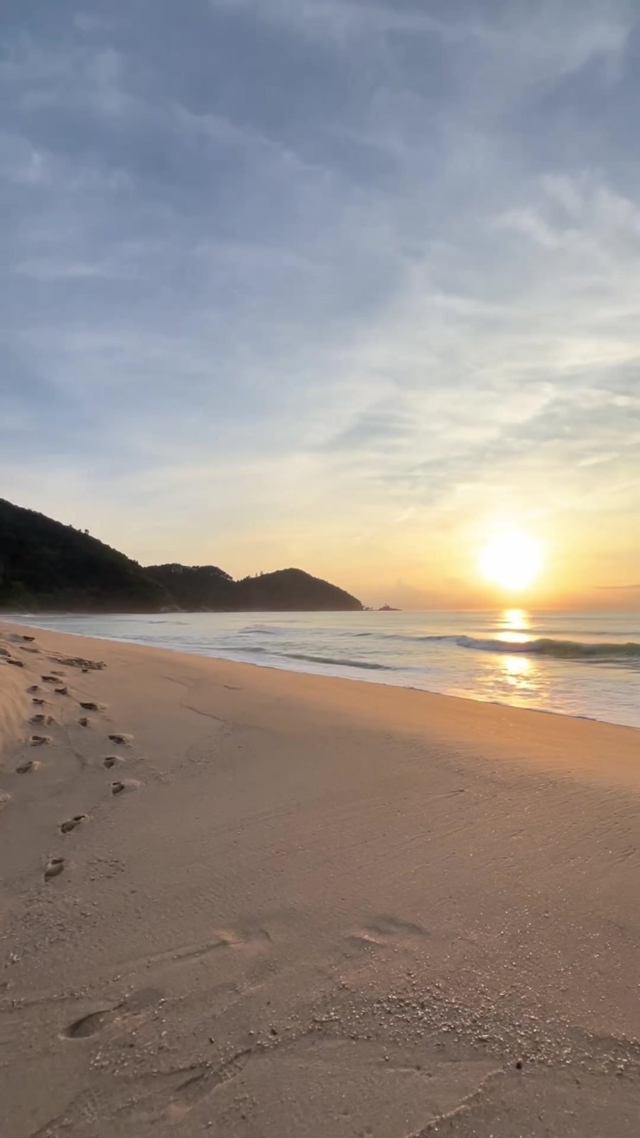 Sol baixo sobre o mar na praia